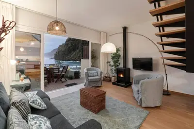 a living room with a couch and chairs and a fireplace at Ocean View in Ponta Delgada