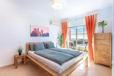 a bedroom with a bed and a large window at Lovely 2 bedroom apartment including pool, stunning ocean views & beach closeby in Luz