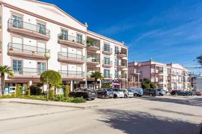 a large apartment building with cars parked in a parking lot at Lovely 2 bedroom apartment including pool, stunning ocean views & beach closeby in Luz