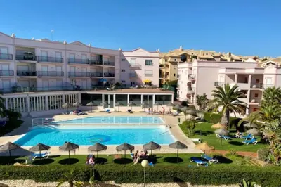 a large swimming pool in front of a building at Lovely 2 bedroom apartment including pool, stunning ocean views & beach closeby in Luz