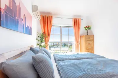 a bedroom with two beds and a large window at Lovely 2 bedroom apartment including pool, stunning ocean views & beach closeby in Luz