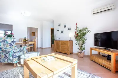 a living room with a television and a table at Lovely 2 bedroom apartment including pool, stunning ocean views & beach closeby in Luz