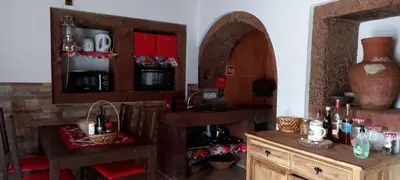 a kitchen with wooden cabinets and a sink and a mirror at Casa da Bisa - Santa Maria - Açores in Santa Bárbara