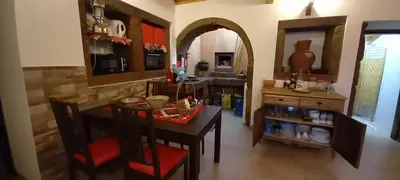 a kitchen with a table and chairs and a kitchen with a counter at Casa da Bisa - Santa Maria - Açores in Santa Bárbara