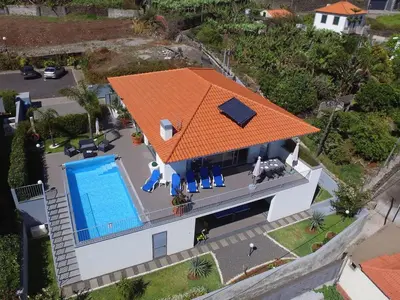 a swimming pool in a backyard at night at Blue Villa in Arco da Calheta