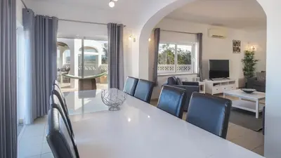 a dining room and living room with a white table and chairs at Casa Monte Cristo IV in Lagos
