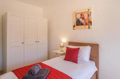 a bedroom with a bed with a red and white blanket at Casa Monte Cristo IV in Lagos