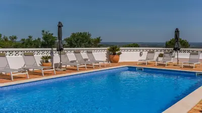 a pool with chaise lounge chairs and a row at Casa Monte Cristo IV in Lagos