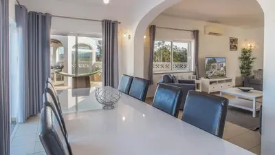 a dining room and living room with a white table and chairs at Casa Monte Cristo IV in Lagos