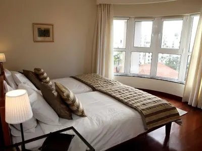 a bedroom with a white bed with pillows and a window at Charming Lido Flat I in Funchal