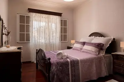 a bedroom with a bed with purple sheets and a window at Welcome home, with a fantastic view, sunrise & sunsets in Estreito da Calheta