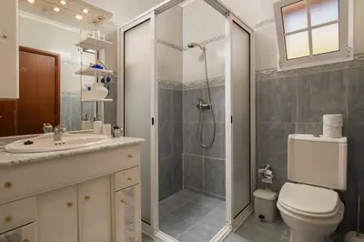 a bathroom with a shower and a toilet and a sink at Welcome home, with a fantastic view, sunrise & sunsets in Estreito da Calheta
