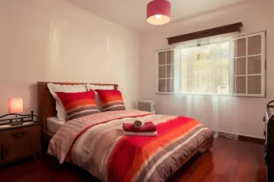 a bedroom with a bed with a stuffed animal on it at Welcome home, with a fantastic view, sunrise & sunsets in Estreito da Calheta