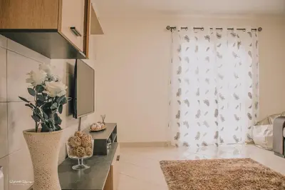 a living room with a vase of flowers and a window at Green Valley House Madeira in Ribeira Brava