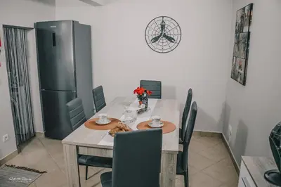 a kitchen with a table with chairs and a refrigerator at Green Valley House Madeira in Ribeira Brava