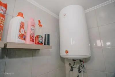 a bathroom with a shelf with detergent and cleaning products at Green Valley House Madeira in Ribeira Brava