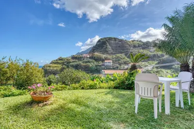 a house with a yard with a table and chairs at Quinta da Vila in Porto da Cruz