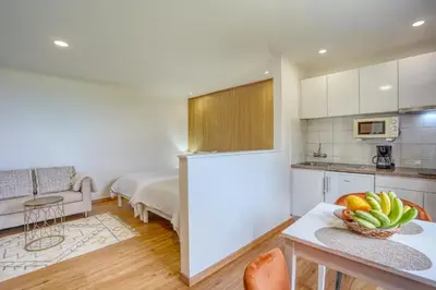 a white bedroom with a bed and a couch at Quinta da Vila in Porto da Cruz