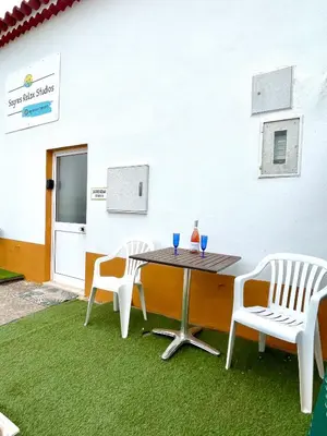 a table with two chairs and a table with two glasses on it at Sagres Relax Studios in Sagres