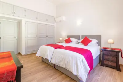 a white bedroom with a large bed with red pillows at Casa Dean by Algarve Golden Properties in Lagos