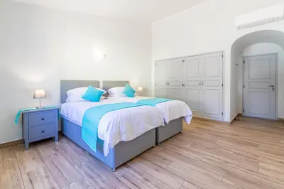 a bedroom with a large bed with blue pillows at Casa Dean by Algarve Golden Properties in Lagos