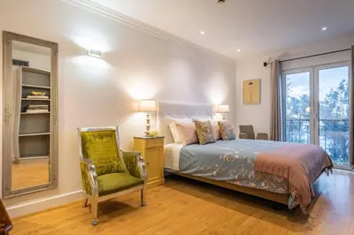 a bedroom with a bed and a chair and a window at Funchal Center Apartment I in Funchal