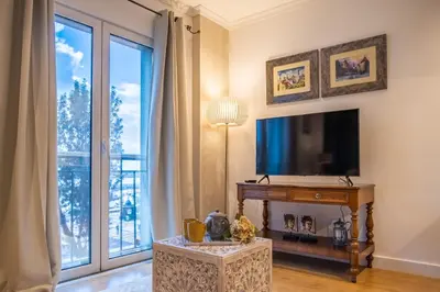 a living room with a tv and a large window at Funchal Center Apartment I in Funchal