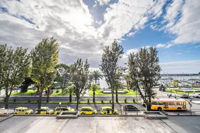 a group of yellow buses parked in a parking lot at Funchal Center Apartment I in Funchal
