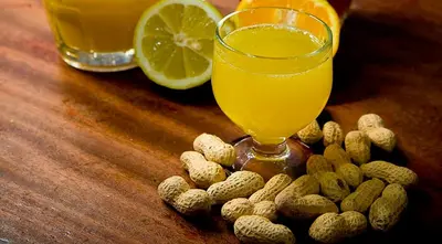 a glass of orange juice and peanuts on a wooden table at Funchal Center Apartment I in Funchal