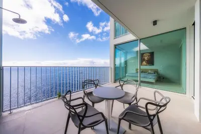 a balcony with a table and chairs and the ocean at Barreirinha Front-Line Sea View I by Holiday Rental Madeira in Funchal