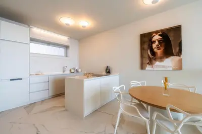 a kitchen with a wooden table and white cabinets at Barreirinha Front-Line Sea View I by Holiday Rental Madeira in Funchal