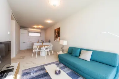 a living room with a blue couch and a table at Barreirinha Front-Line Sea View I by Holiday Rental Madeira in Funchal