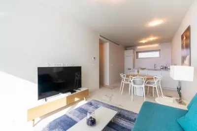 a living room with a couch and a tv and a table at Barreirinha Front-Line Sea View I by Holiday Rental Madeira in Funchal