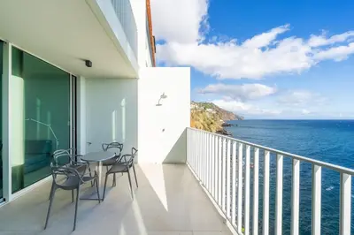 a balcony with chairs and a view of the ocean at Barreirinha Front-Line Sea View I by Holiday Rental Madeira in Funchal