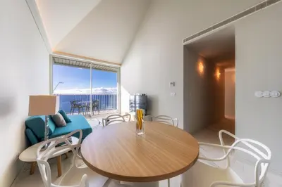 a dining room with a wooden table and chairs at Barreirinha Front-Line Sea View II by Holiday Rental Madeira in Funchal