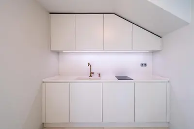 a kitchen with white cabinets and a sink at Barreirinha Suite Top Floor by Holiday Rental Madeira in Funchal