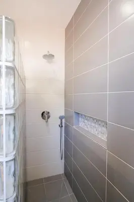 a bathroom with a shower with a tiled wall at Casa Monte Cristo Tres in Lagos