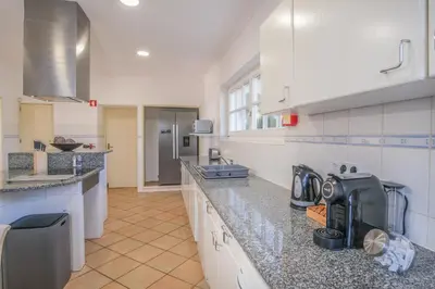 a large kitchen with white cabinets and granite counter tops at Casa Monte Cristo Tres in Lagos