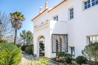 an exterior view of a white house with a palm tree at Casa Monte Cristo Tres in Lagos