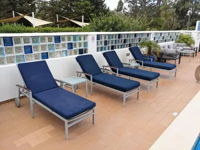 a row of blue chairs sitting on a patio at Casa Monte Cristo Apartments - Almond in Lagos