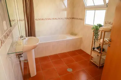 a bathroom with a sink and a bath tub at O DRAGOEIRO da Madalena! in Porto Santo
