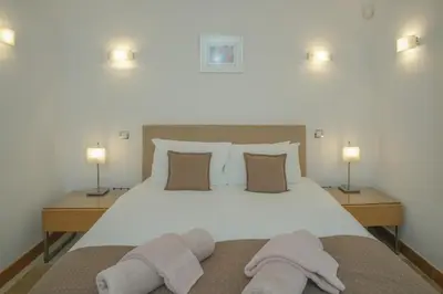 a bedroom with a large bed with two towels on it at Casa Monte Cristo Apartments - Lemon in Lagos