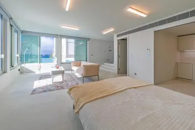 a bedroom with a large bed and a living room at Barreirinha Suite by Holiday Rental Madeira in Funchal