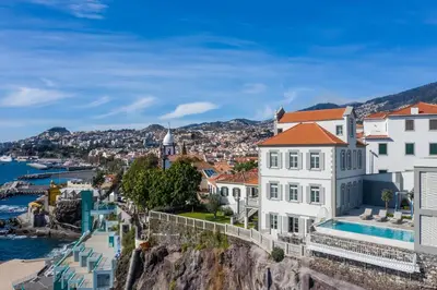 a group of buildings on a cliff next to the water at Barreirinha Suite by Holiday Rental Madeira in Funchal