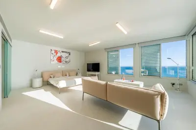 a living room with a couch and a bed and windows at Barreirinha Suite by Holiday Rental Madeira in Funchal