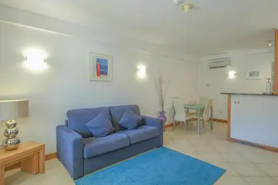 a living room with a blue couch and a table at Casa Monte Cristo Apartments - Plum in Lagos