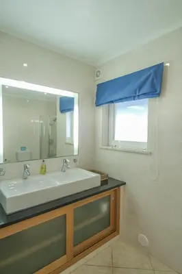 a bathroom with a sink and a mirror at Casa Monte Cristo Apartments - Plum in Lagos