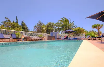 a large swimming pool with chairs and an umbrella at Casa Monte Cristo Apartments - Plum in Lagos