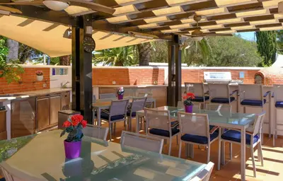 a patio with tables and chairs under an umbrella at Casa Monte Cristo Apartments - Lime in Lagos