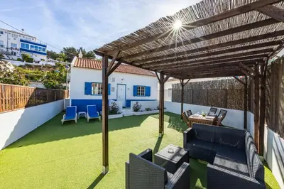 a patio with a wooden pergola at Salema Beach House in Salema